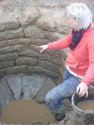 Figure 3 - Becky Kelly Excavating the Base of the Well (Image Copyright - Cath Neal/University of York Archaeology Department)